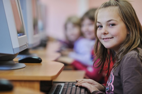 Girl Smiling While Sitting at Computer