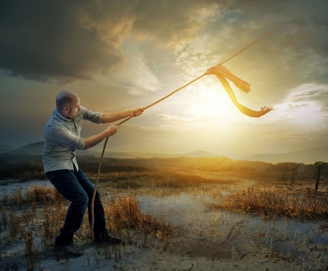 A man pulling a rope connected into the sky